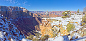 A hiker standing on a snowy cliff on the east rim of Grand Canyon National Park, UNESCO World Heritage Site, Arizona, United States of America, North America