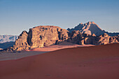 Morgenlicht auf Bergen über der roten Sanddüne von Wadi Rum, UNESCO-Welterbe, Jordanien, Naher Osten