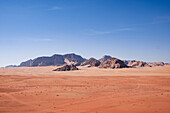 Roter Sand und Berge unter blauem Himmel in der Wüste Wadi Rum, Jordanien, Naher Osten
