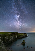Die Milchstraße und der Nachthimmel über Gwenfaens Pillar, Porth Saint, bei Rhoscolyn, Anglesey, Nordwales, Vereinigtes Königreich, Europa