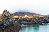 Einsames Haus über dem Basaltfelsen in der Nähe des Hafens, Arnarstapi, Snaefellsjokull-Nationalpark, Halbinsel Snaefellsness, Vesturland, Westisland, Island, Polarregionen