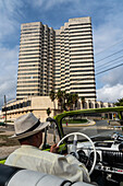 Fahrer mit Panamahut in grünem Chevrolet Oldtimer mit offenem Verdeck fährt durch die Stadt, Havanna, Kuba, Westindien, Karibik, Mittelamerika