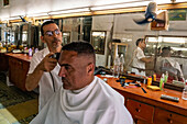 Cuban having his haircut, Old Havana, Cuba, West Indies, Caribbean, Central America