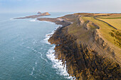 Aerial view of Gower's dramatic limestone cliffs, looking towards Worm's Head, Gower Peninsula, South Wales, United Kingdom, Europe