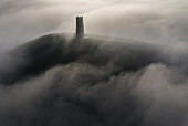 Aerial view of St. Michael's Tower on Glastonbury Tor surrounded by a sea of mist in winter, Glastonbury, Somerset, England, United Kingdom, Europe