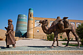 Skulptur eines Kamelzugs, im Hintergrund das Kalta-Minarett, Ichon Qala (Itchan Kala), UNESCO-Welterbe, Chiwa, Usbekistan, Zentralasien, Asien