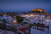 View of Lindos and Lindos Acropolis from elevated position at dusk, Lindos, Rhodes, Dodecanese Island Group, Greek Islands, Greece, Europe