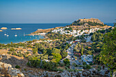 View of sailboats in the bay, Lindos and Lindos Acropolis from elevated position, Lindos, Rhodes, Dodecanese Island Group, Greek Islands, Greece, Europe