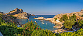 View of sailboats in the bay, Lindos and Lindos Acropolis from elevated position, Lindos, Rhodes, Dodecanese Island Group, Greek Islands, Greece, Europe