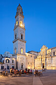 Beleuchteter Campanile und Kathedrale mit Cafés bei Nacht auf der Piazza del Duomo, Lecce, Apulien, Italien, Europa