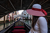 Young girl in a gondola tour in Venice, Veneto, Italy, Europe