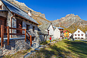 Hiker reaches the Pedemonte village, Alpe Devero, Baceno, Alpe Veglia and Alpe Devero natural park, province of Verbano-Cusio-Ossola, Piedmont, italy, Europe (MR)