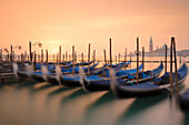 a long exposure to capture the Gondolas near St Mark Square with San Giorgio Island on the background during sunrise, municipality of Venice, Venezia province, Veneto district, Italy, Europe