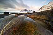 eine Langzeitbelichtung, um das Licht des Sonnenuntergangs am Uttakleiv Strand an einem Wintertag einzufangen, mit dem berühmten Drachenauge im Vordergrund, Vestvagoy, Lofoten Insel, Norwegen, Europa