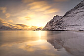 eine Langzeitbelichtung, um das Licht des Sonnenuntergangs am Strand von Haukland an einem Wintertag einzufangen, Vestvagoy, Lofoten, Norwegen, Europa