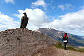 Ein Wanderer am Christomannos-Denkmal, mit der Latemar-Gruppe im Hintergrund, Dolomiten, Rosengartengruppe, Fassatal, Provinz Trient, Trentino-Südtirol, Italien