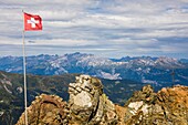 Swiss flag fluttering at the summit of the parpaner rothorn, alpine resort of lenzerheide, swiss alps, canton of the grisons, switzerland