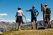 Hikers admiring the view of the alpine landscape from the weisshorn, tourism, swiss alps, resort of arosa, canton of the grisons, switzerland