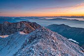 Farbenfroher Himmel bei Sonnenaufgang, gesehen von einem Gipfel in den Brenta-Dolomiten, oberhalb des Tovel-Sees in der Provinz Trient, Region Trentino-Südtirol, Italien.