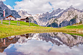 Lamsenspitze und das Karwendelgebirge spiegeln sich in einem Teich auf der Walder Alm, Gnadenwald, Innsbruck LAnd, Tirol, Österreich