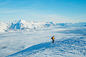 Ein Bergsteiger beim Schneeschuhwandern auf dem Patscherkofel mit dem nebelverhangenen Inntal im Hintergrund, Patscherkofel, Innsbruck Land, Tirol, Österreich, Europa