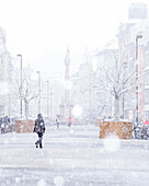 Eine Frau geht an einem verschneiten Tag in der Maria-Theresien-Straße spazieren, Innsbruck, Innsbruck Stadt, Tirol, Österreich, Europa