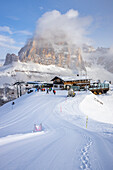 Italien, Venetien, Provinz Belluno, Skifahrer auf der Scoiattoli-Hütte mit Tofana di rozes im Hintergrund