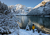 Italy, South Tyrol, Bolzano province, hiker admires Croda del Becco from the shores of Braies lake (MR)