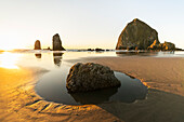 Die Needles-Felsen am Cannon Beach bei Sonnenuntergang, bei Ebbe. Landkreis Clatsop, Oregon, USA.
