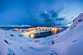 Das Küstendorf Sorvaer ist während der Dämmerung im kalten arktischen Winter mit Schnee bedeckt (Insel Soroya, Hasvik, Troms og Finnmark, Norwegen)