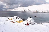 Das Küstendorf Breivik ist während des kalten arktischen Winters mit Schnee bedeckt (Insel Soroya, Hasvik, Troms og Finnmark, Norwegen)