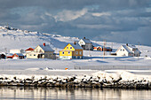 Hasvik Village: schneebedeckte Häuser während des kalten arktischen Winters (Soroya Island, Troms og Finnmark, Norwegen)