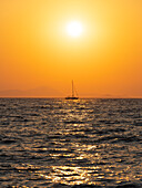 Italy, Tuscany, Punta Ala, Cala Violino, Sail boat at sunset