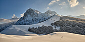 Sanfte, mit Neuschnee bedeckte Hügel, die zu den höchsten Gipfeln des Gran Sasso führen, bei Sonnenuntergang. Pietracamela, Bezirk Teramo, Abruzzen, Italien