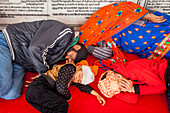 Pilgrims (family) sleeping, after a hard trip, inside of Golden temple, Amritsar, Punjab, India