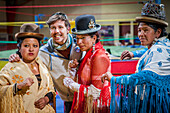 Lucha Libre. Nach der Show. Eine Anhängerin wird mit Cholitas-Kämpfern fotografiert. Links Julieta, in der Mitte Celia la Simpatica, und Dina, Cholitas Wrestlerinnen, Sportzentrum La Ceja, El Alto, La Paz, Bolivien