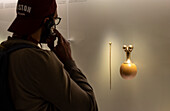 Visitor observing Poporo and stick, Pre-Columbian goldwork collection, Gold museum, Museo del Oro, Bogota, Colombia, America