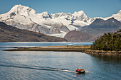 Cordillera Darwin and explorers riding a zodiac, in Ainsworth Bay, PN Alberto de Agostini, Tierra del Fuego, Patagonia, Chile