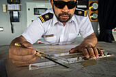 Officer calculating the course of the ship, ship's bridge, Ventus cruise ship, Nassau bay, near Cape Horn, Tierra de Fuego, Patagonia, Chile