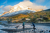 Hikers crossing river and walking between Torres refuge and Cuernos refuge, Torres del Paine national park, Patagonia, Chile