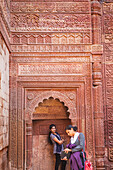 Carved wall and visitors, in Qutub Minar complex, Delhi, India
