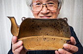Nizaemon Koizumi shows the rusty of inside in a iron teapot or tetsubin, nanbu tekki, Workshop of Koizumi family,craftsmen since 1659, Morioka, Iwate Prefecture, Japan