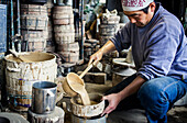 Takahiro Koizumi is sifting water to make mud, and build a molds to make iron teapot or tetsubin, nanbu tekki, Workshop of Koizumi family,craftsmen since 1659, Morioka, Iwate Prefecture, Japan