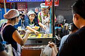 Cooking khanom buang sweet coconut crepes, Street food night market, at Yaowarat road, Chinatown, Bangkok, Thailand