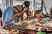 Collectors with magnifying glass searching small Buddhist amulets, Amulet market, Bangkok, Thailand, Asia
