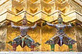 Dämonenstatuen auf einer goldenen Chedi, im Tempel des Smaragdbuddhas Wat Phra Kaeo, Großer Palast, Bangkok, Thailand