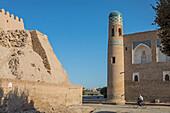 Straßenszene in Ichon-Qala oder Altstadt, links Stadtmauern und rechts Muhammad Amin Khan Medressa, Chiwa, Usbekistan