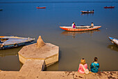 Betender Mann und Touristen, in Lalita ghat, Fluss Ganges, Varanasi, Uttar Pradesh, Indien.