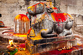 Shiva ling and sacred cow statue, ghats of Ganges river, Varanasi, Uttar Pradesh, India.