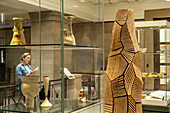 Frau bei der Betrachtung der mehrteiligen Säulenskulptur von David Nash, National Museum of Wales, Cardiff, Wales